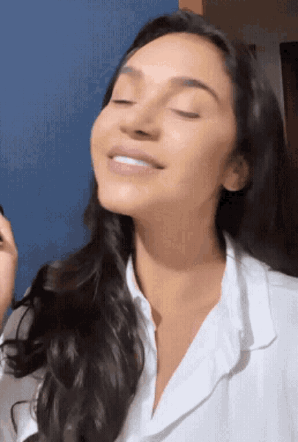 a woman is smiling with her eyes closed