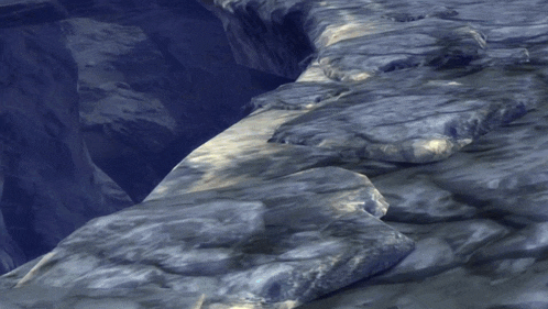 a computer generated image of a rocky cliff with a blue sky in the background