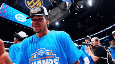 a man wearing a hat and a shirt that says champs