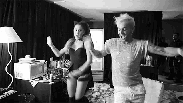 a man and a woman are dancing together in a room .