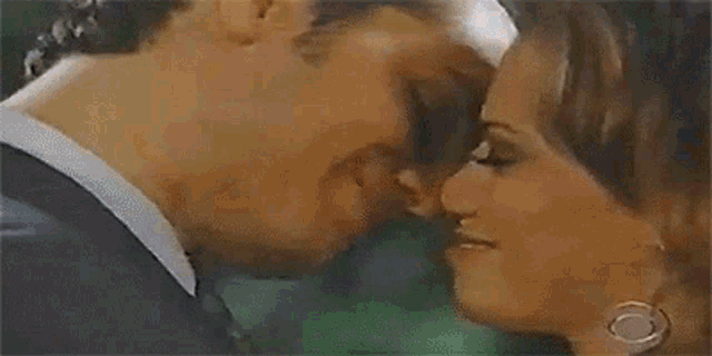 a man and a woman are kissing each other in a bathtub .