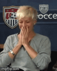 a woman covering her mouth with her hands in front of a us soccer emblem