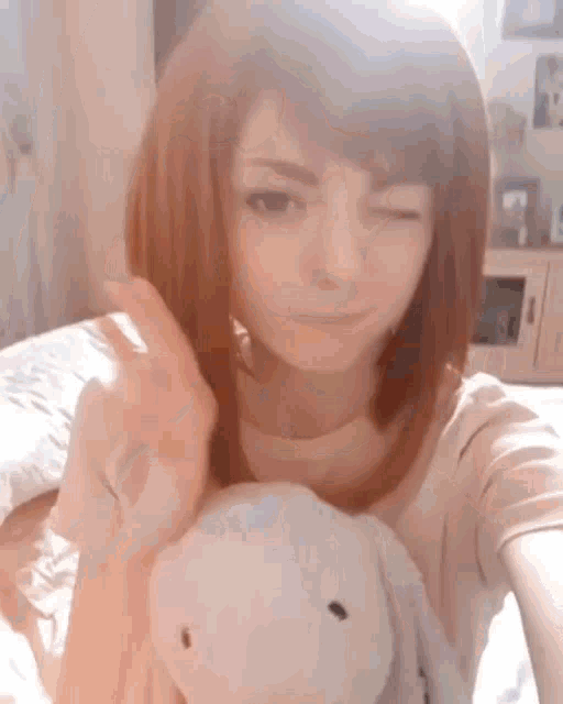 a woman is taking a selfie with a stuffed bunny rabbit .