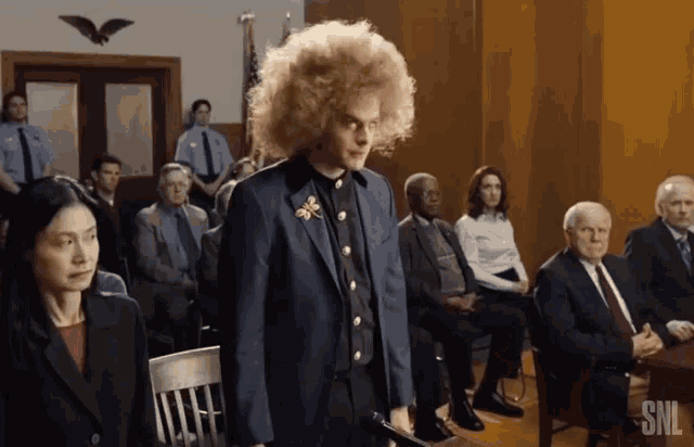 a man in a suit stands in front of a snl ad