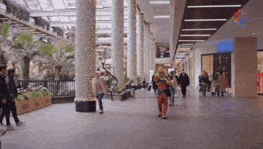 a man in a clown costume is walking in a mall