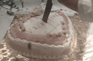 a person is cutting a heart shaped cake that says valentine on it