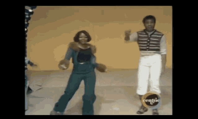 a man and a woman are dancing in front of a yellow wall with the word centic on the bottom