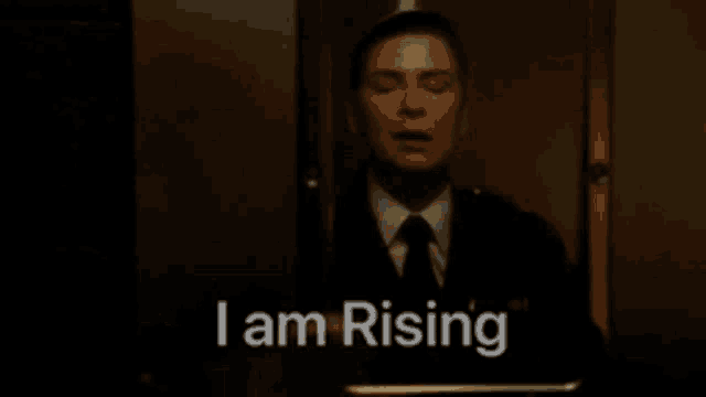 a man in a suit and tie says i am rising with his eyes closed