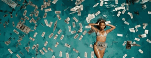 a woman in a bikini is laying in a pool of money with twenty dollar bills falling from the sky