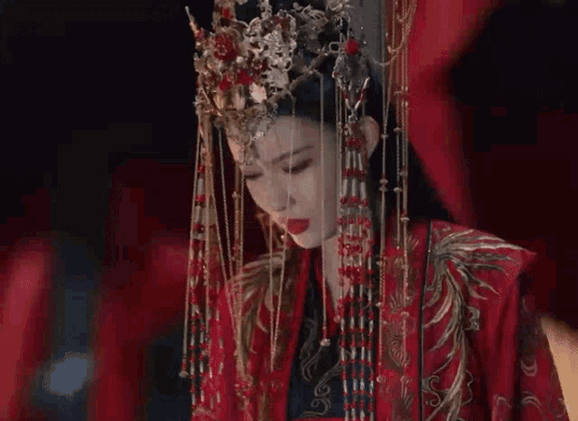 a woman is wearing a red dress and a tiara .