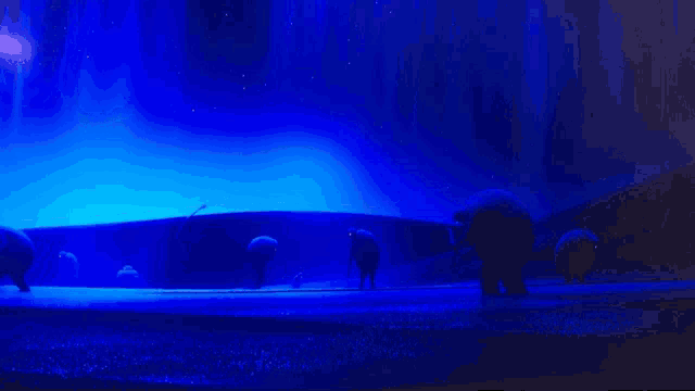 a group of elephants standing in front of a blue background