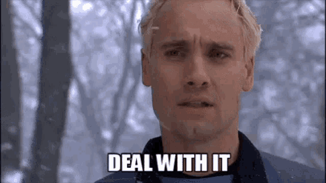 a man with blonde hair is standing in the snow with the words `` deal with it '' written on his face .