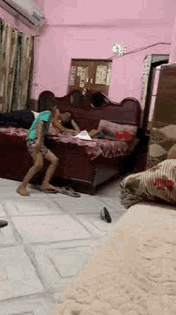 two children are playing in a living room with a bed .
