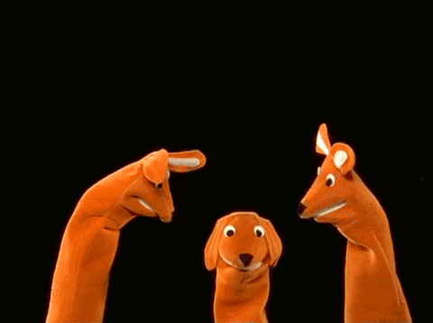 three orange hand puppets in the shape of a kangaroo , a dog , and a rabbit .