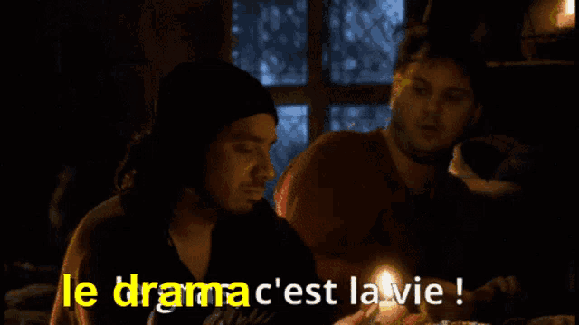 a man holding a lit candle with the words le dramac c'est la vie