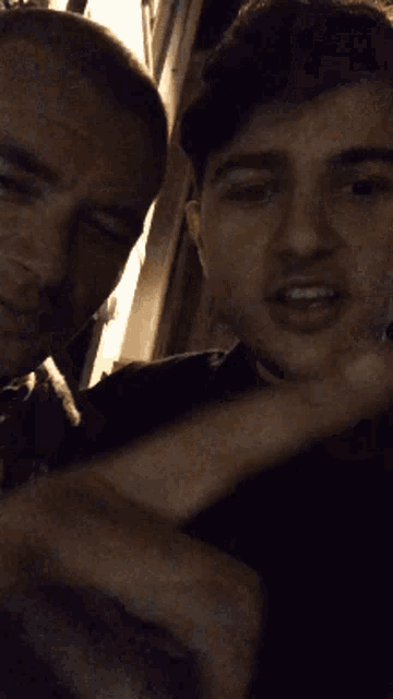 two men are posing for a picture together and one of them is smiling