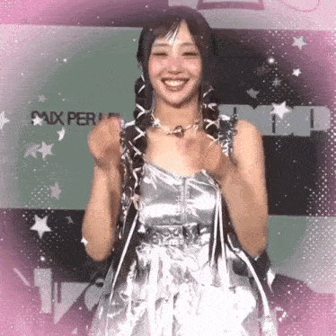 a woman in a silver dress is smiling in front of a sign that says " paix "
