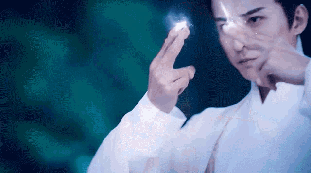 a man in a white shirt is holding something in his hands