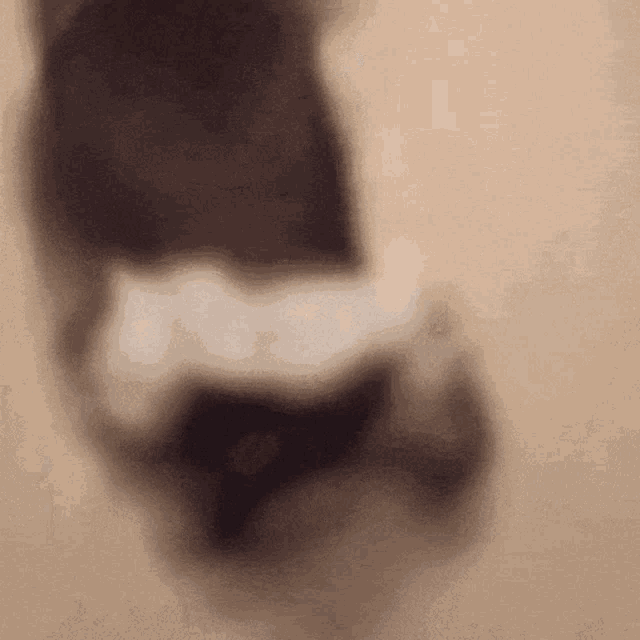 a blurred image of a person 's foot on a beige background