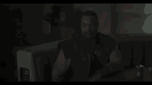 a man in a dark room with the words all of them on the screen