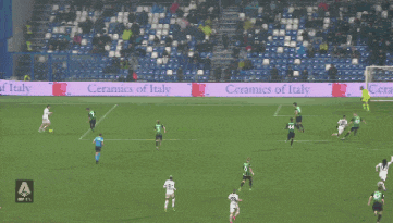 a soccer game is being played in front of a ceramics of italy sign