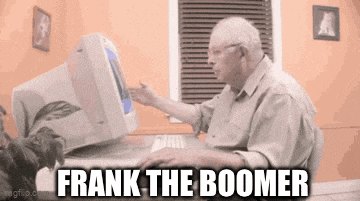 an elderly man is sitting at a desk in front of a computer and using a keyboard .