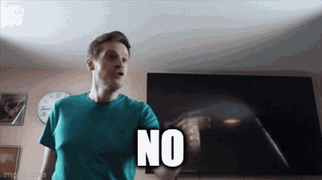 a man in a blue shirt is holding a remote control and says no
