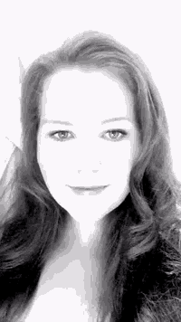 a black and white photo of a woman with long red hair and blue eyes .