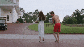 a man and woman are dancing in front of a golf cart