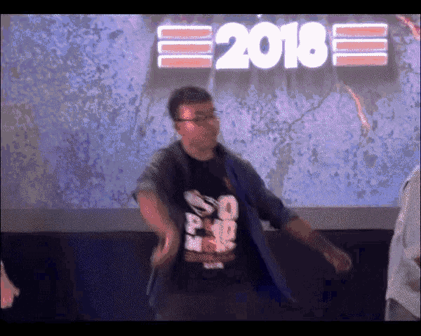 a man is dancing in front of a screen that says 2018