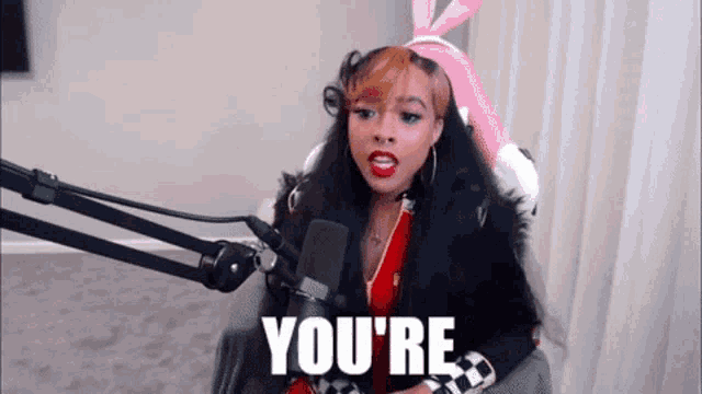 a woman is sitting in front of a microphone and saying you 're