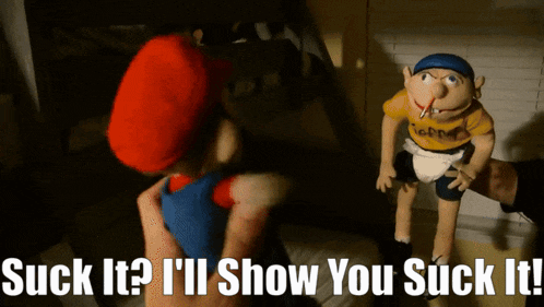 a mario puppet is being held by another mario puppet with the words " suck it " written on the bottom