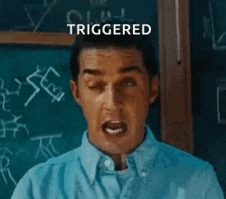 a man is making a funny face in front of a blackboard that says triggered .