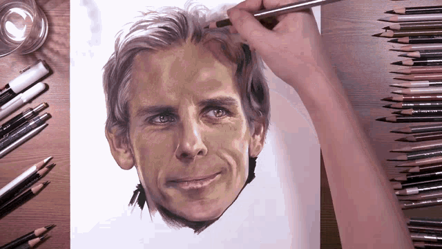 a person is drawing a man 's face on a piece of paper with colored pencils on the table