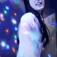 a woman in a white shirt is dancing in front of a blue background with lights .