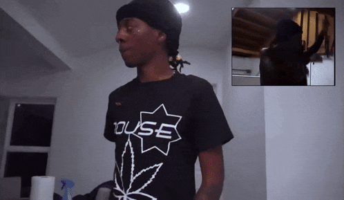 a man wearing a black t-shirt with the word house on it