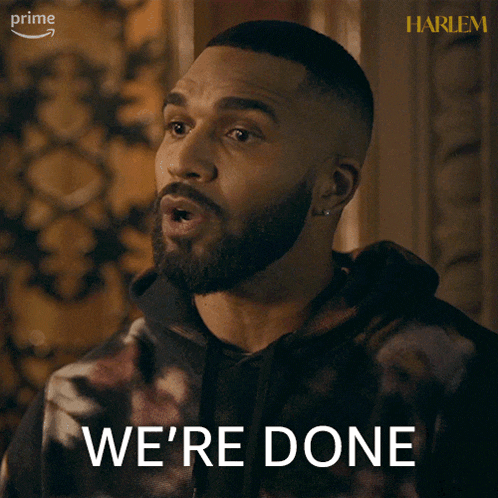 a man with a beard says we 're done in front of a harlem poster