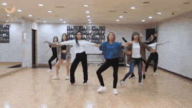 a group of young women are dancing in a room with a sign that says ' a ' on it