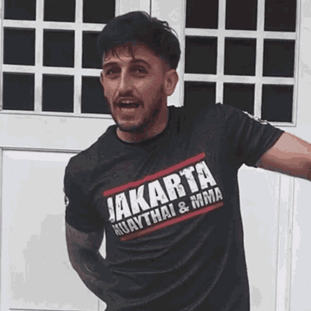a man wearing a black shirt that says jakarta muaythai and mma
