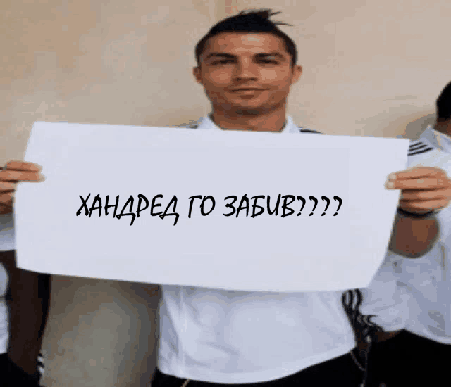 a man in a white shirt is holding a sign that says hundred to zabiv
