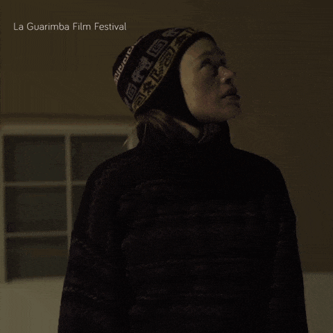 a woman wearing a sweater and a hat with the words la guarimba film festival on the bottom right