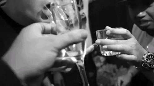 a black and white photo of people toasting with glasses