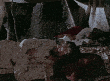 a close up of a woman sleeping on a bed with her eyes closed