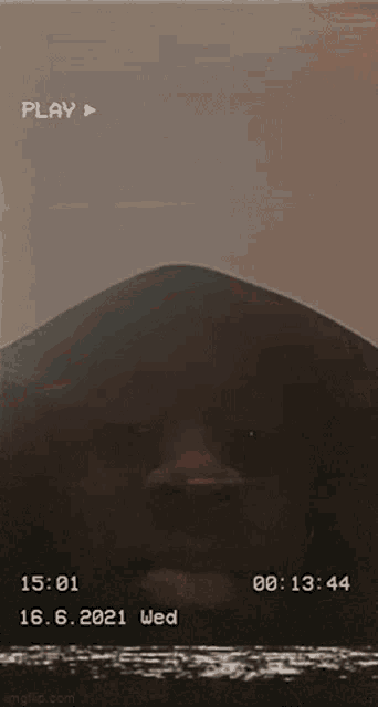 a close up of a person 's face with a play button on the bottom