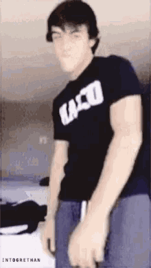 a young man wearing a black t-shirt with the word taco on it .