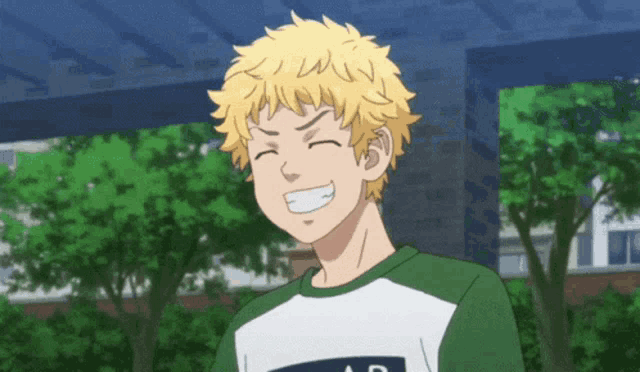 a young man with blonde hair is smiling with his eyes closed .