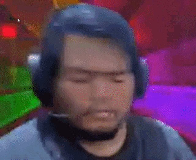 a blurry picture of a man wearing headphones against a colorful background .