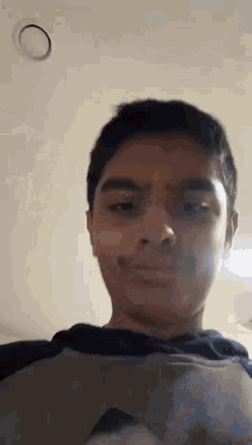 a young boy is making a funny face while wearing a hoodie .