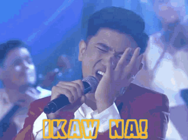 a man singing into a microphone with the words ikaw na written on the bottom