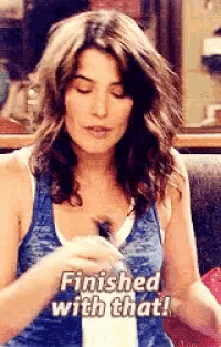a woman in a blue tank top is sitting at a table with her eyes closed and says `` finished with that '' .